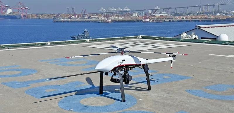 White Velos V3 UAV helicopter on the ground at harbor, used for maritime infrastructure and emission inspections